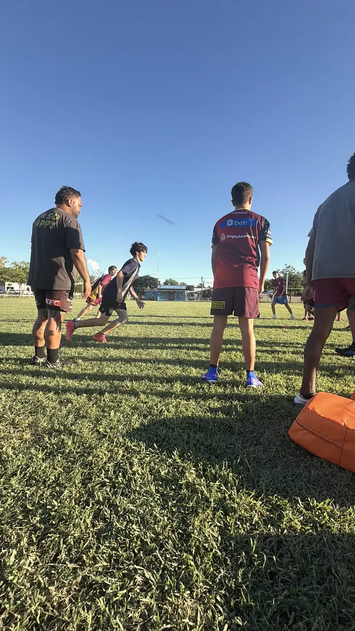 A coach watching players run a drill at training