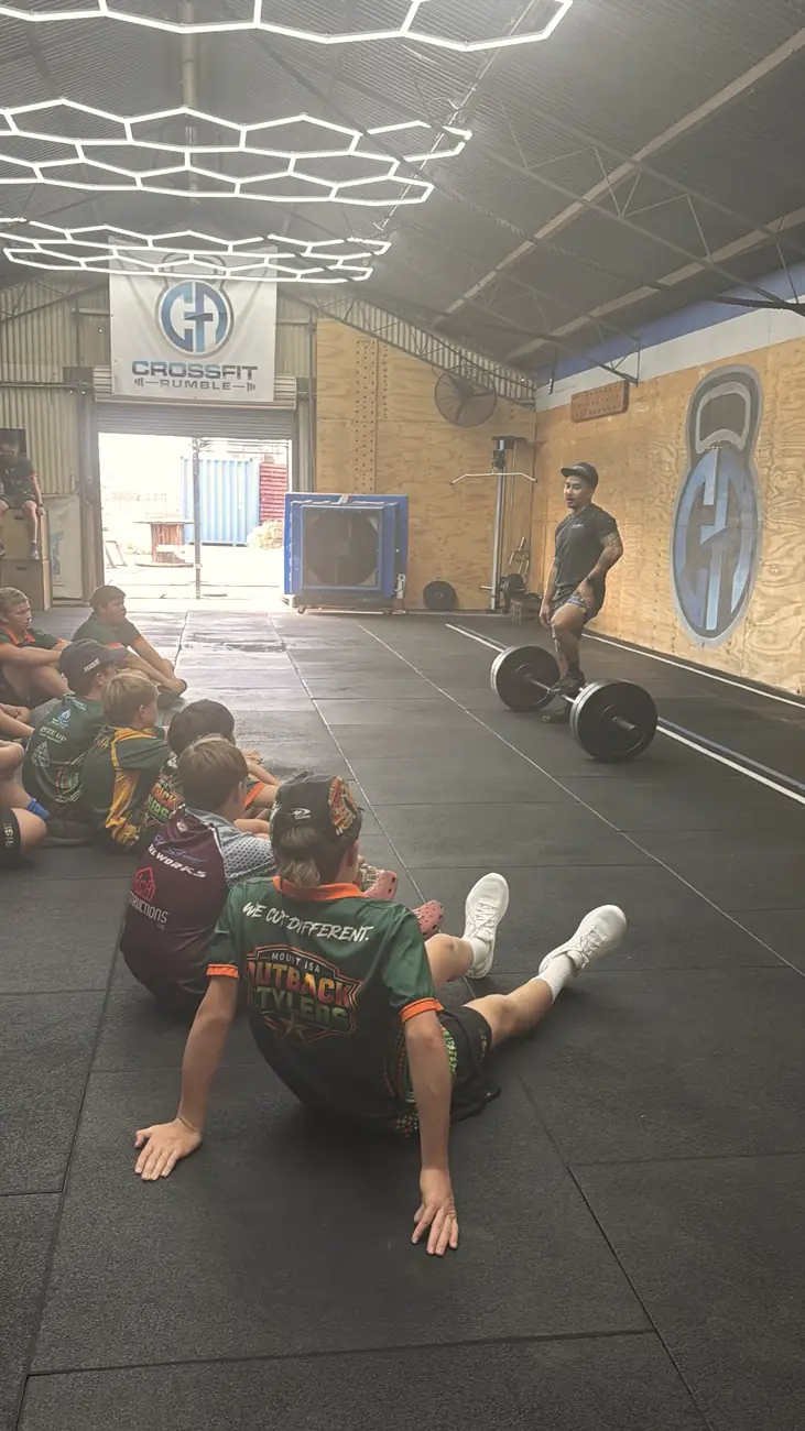 A Stylers player in his We Cut Different jersey listening to the coach at CrossFit Rumble
