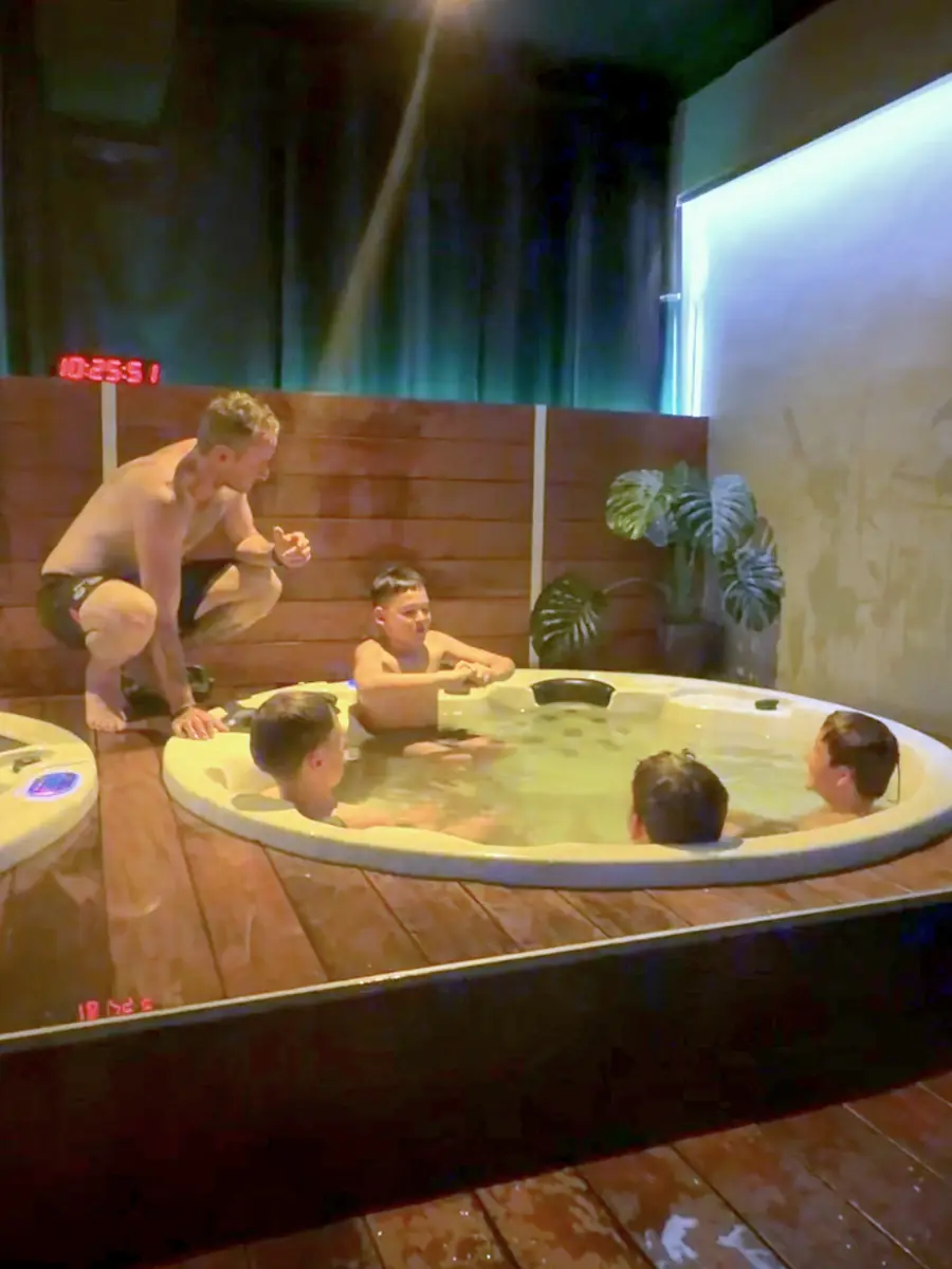 Players relaxing in the spa with their coach during a recovery session