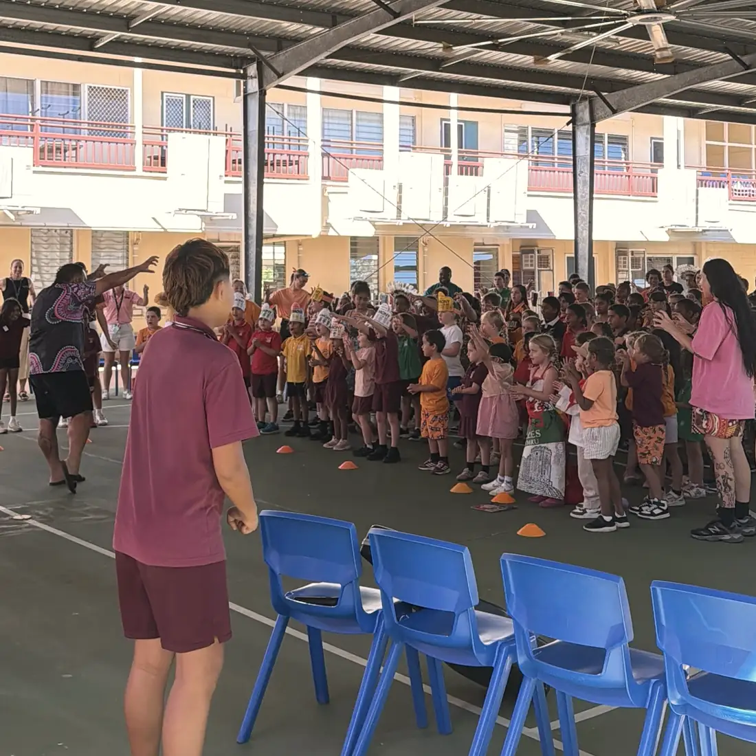 The whole school doing the actions together under the covered court