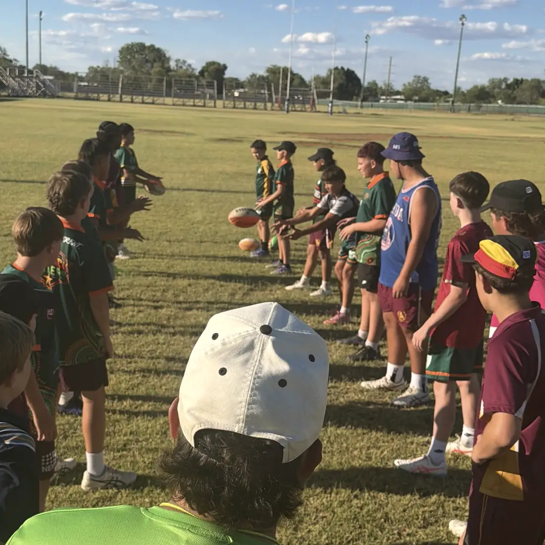 An Outback Stylers coach watching two lines of players run passing drills
